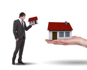 man looking at two different sized homes