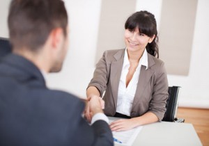 woman shaking hands with a man at a meeting