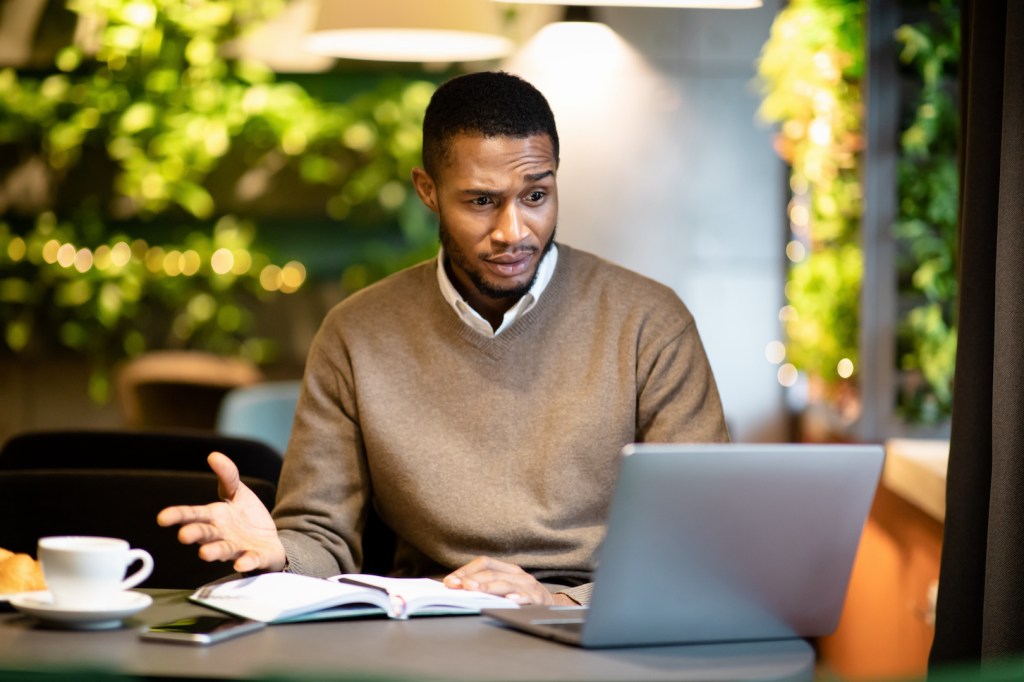 Man looking at apartment reviews on a laptop