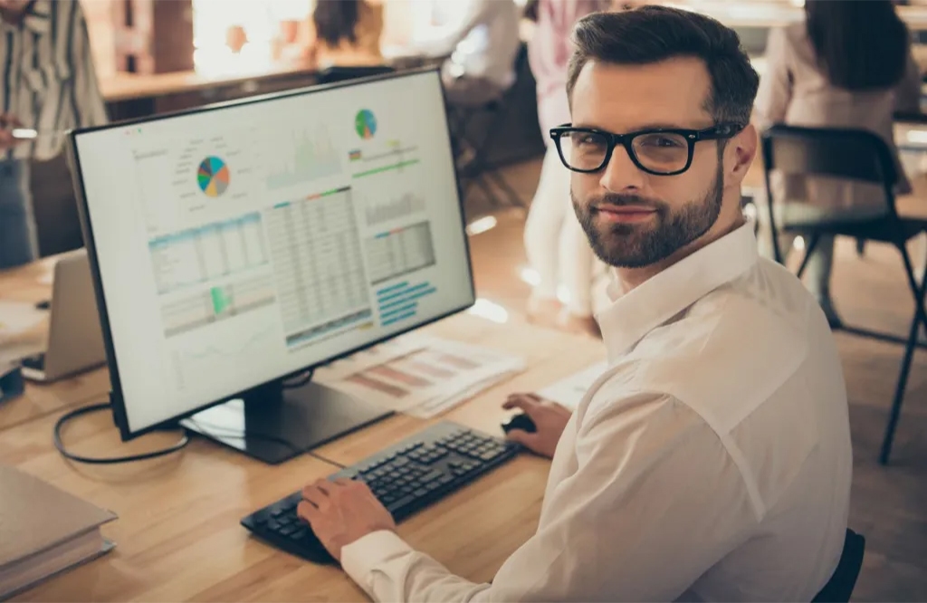 Man seated at a computer using multifamily crm technology