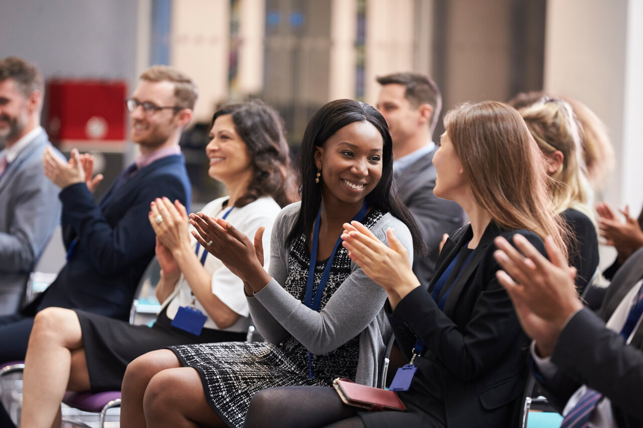 People clapping at an event or conference showing gratitude