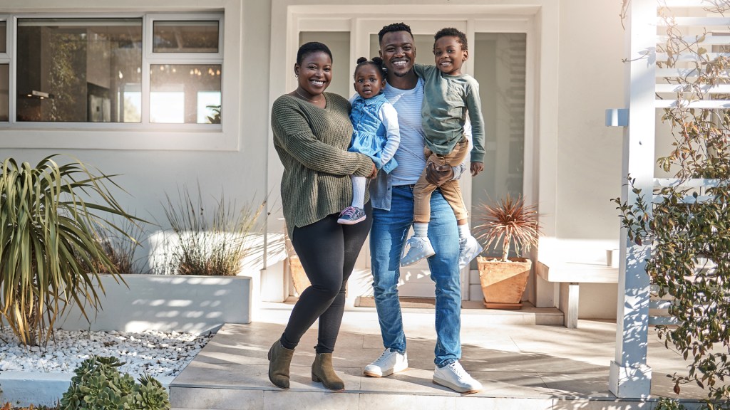 Family standing together in front of a house
