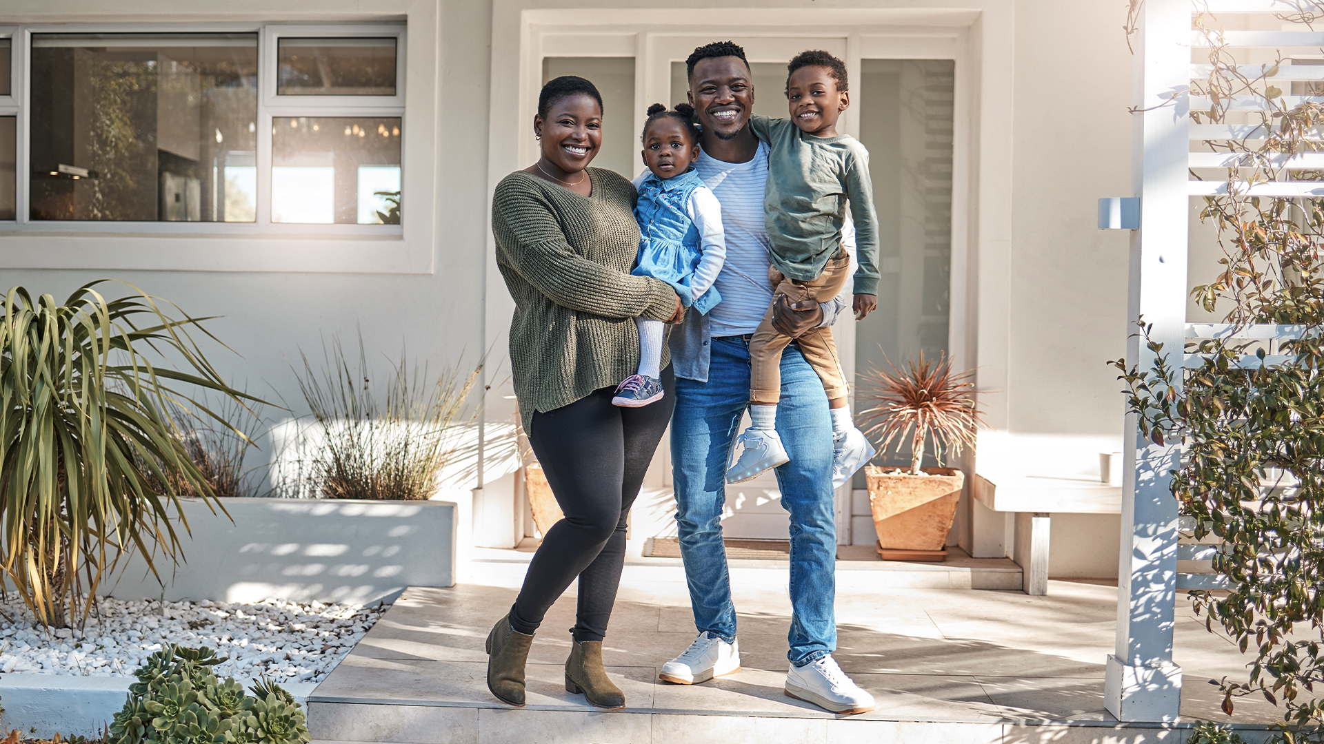 Family standing together in front of a house
