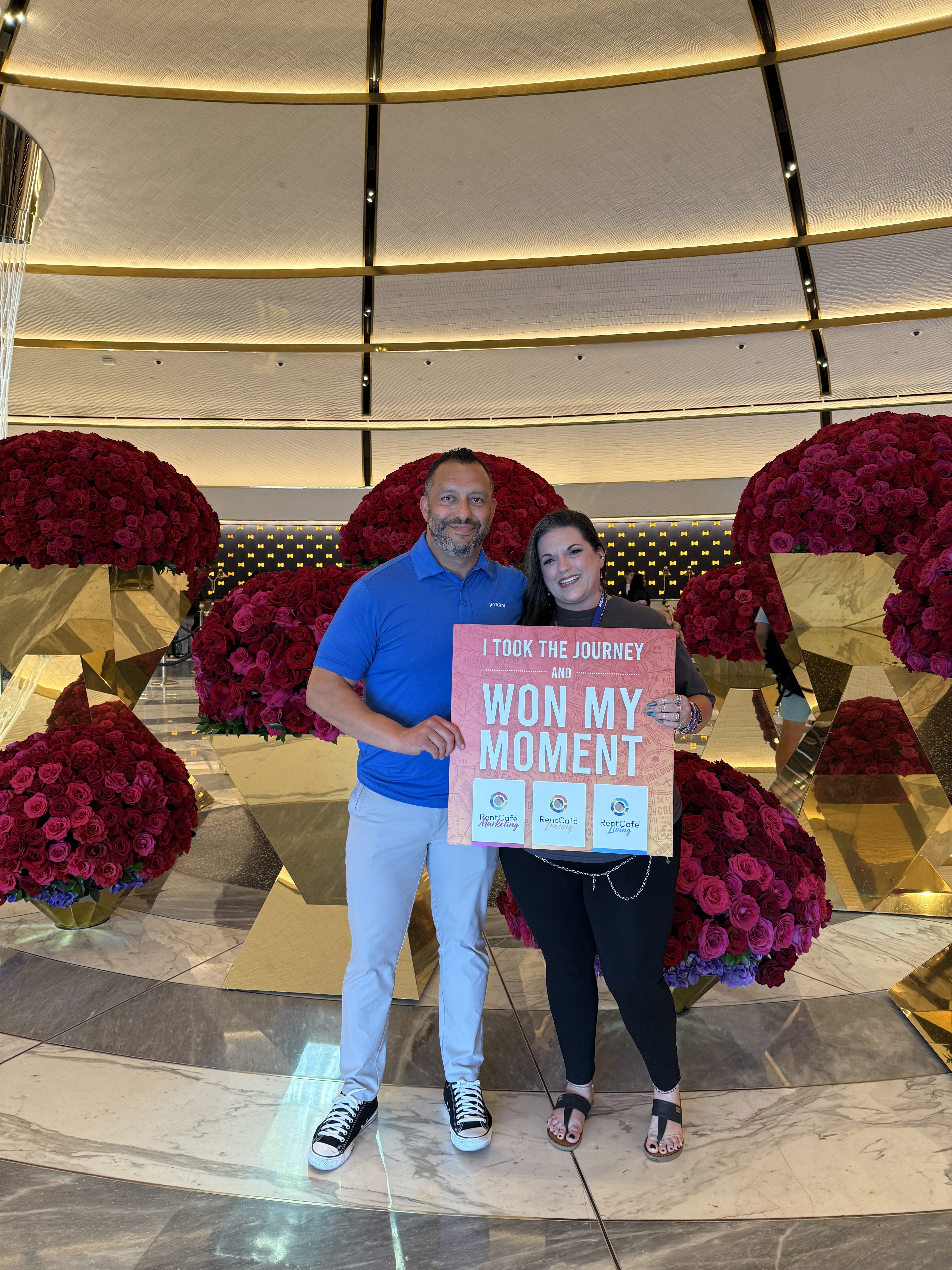Two people holding sign at NAA Apartmentalize 2025