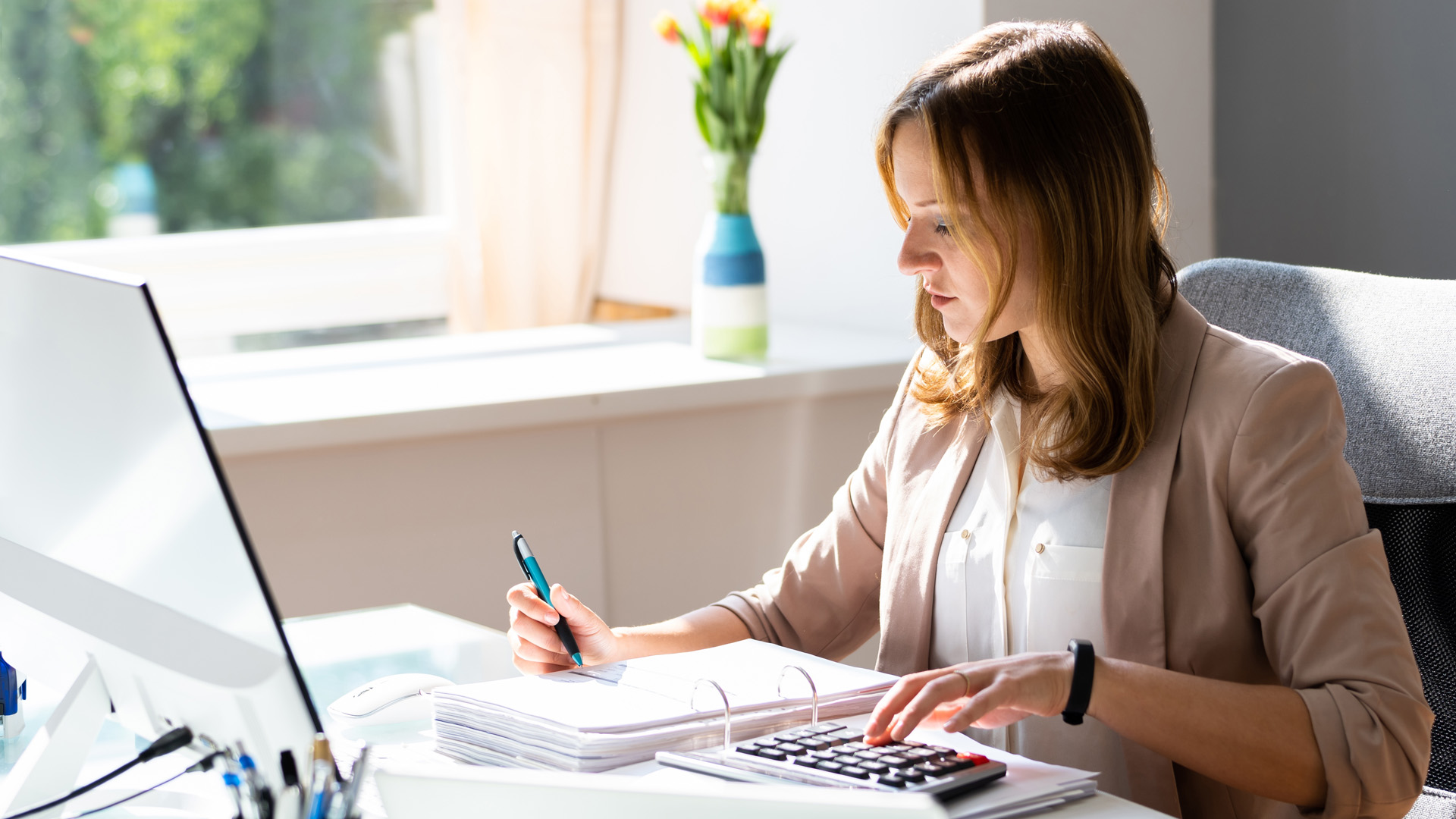 Woman doing calculations at her computer