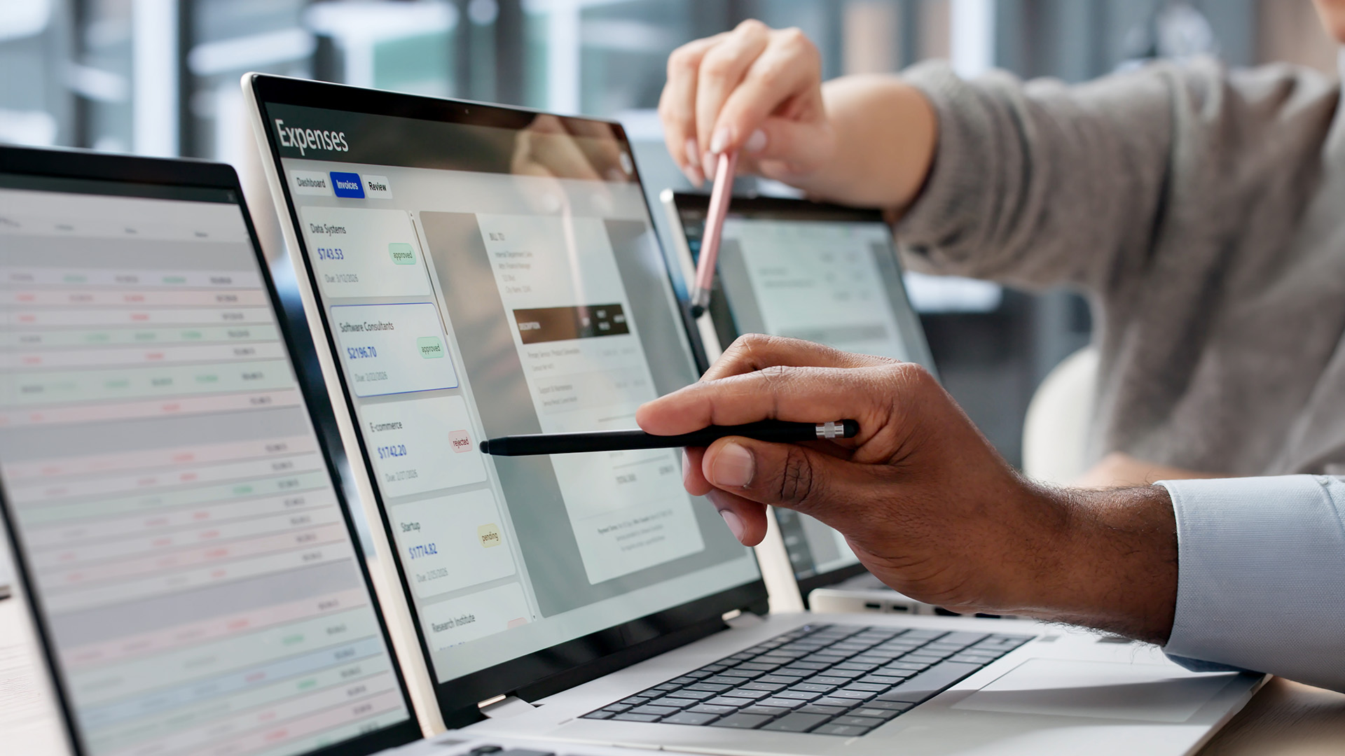 People pointing at investment management screens on a laptop