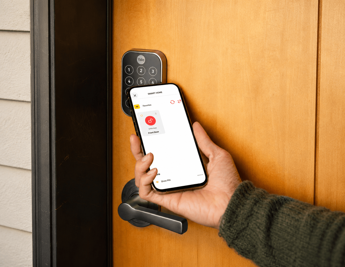 Phone with digital key screen held up to door lock