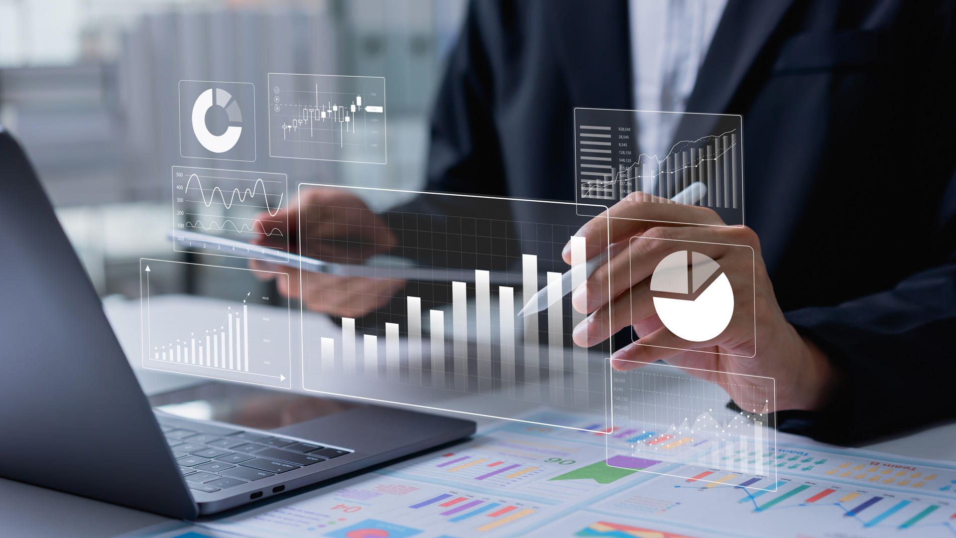 Man using laptop with finance-related graphics appearing in front of him.