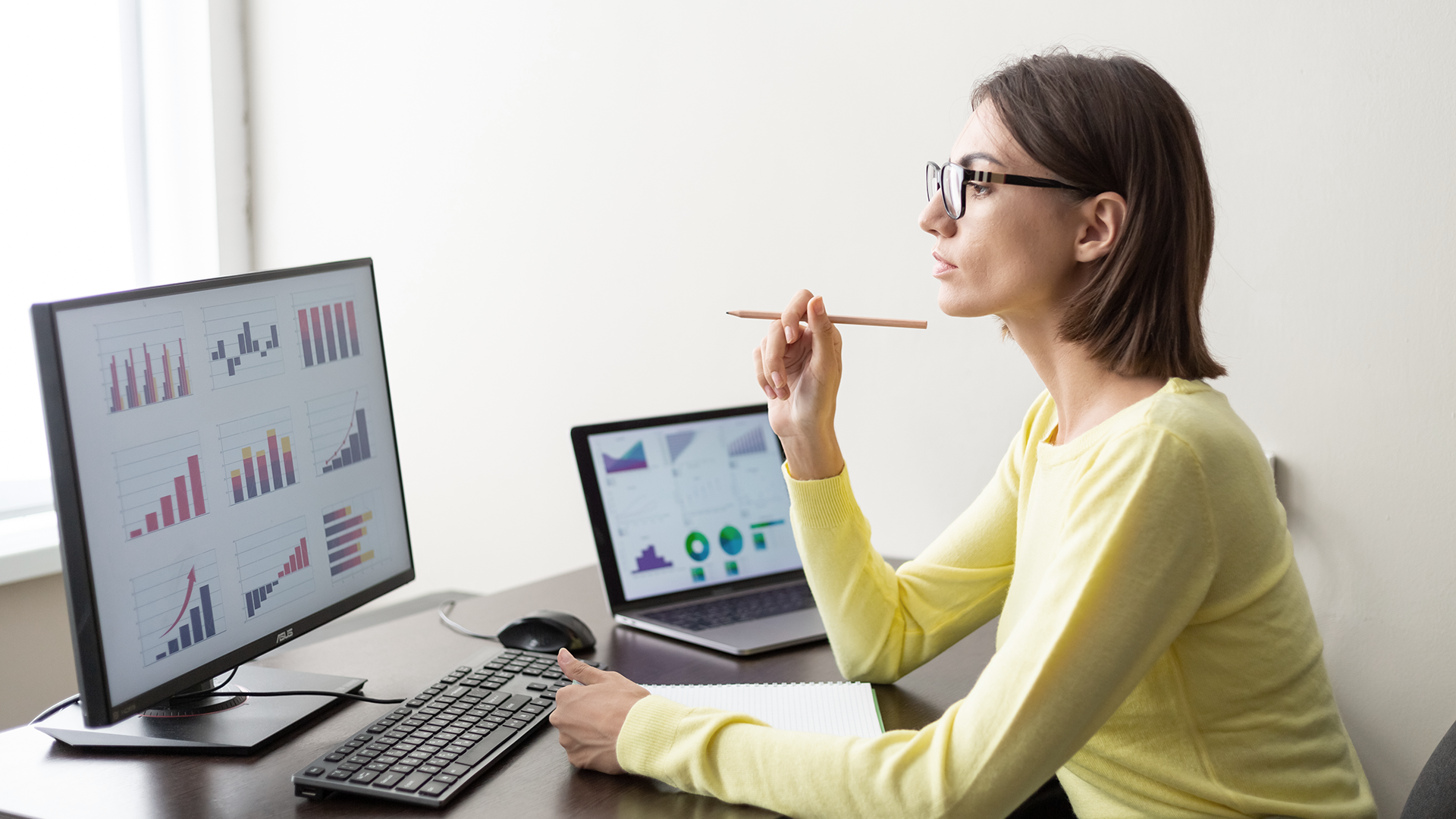 Analyst reviewing performance charts on two screens