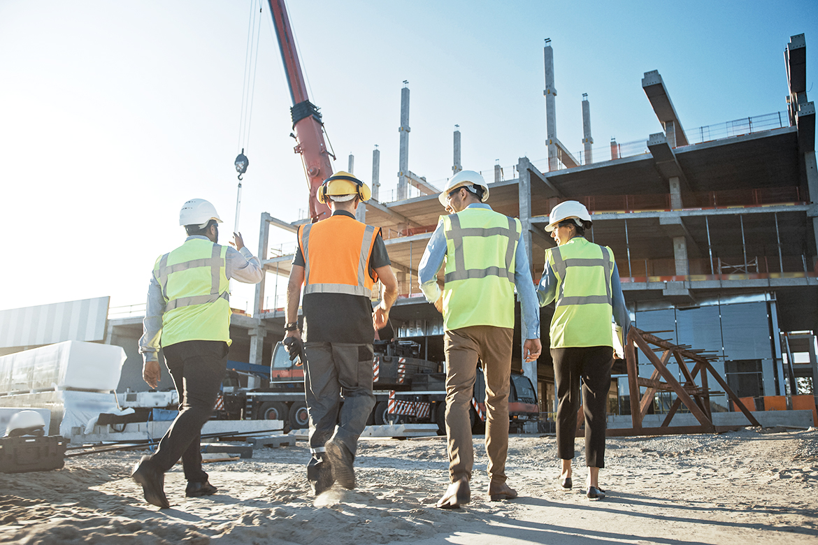 Four workers survey construction site