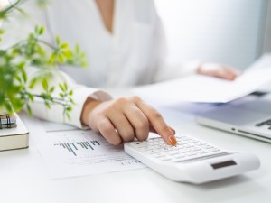 Image of person using a calculator at desk while using Voyager Accounting
