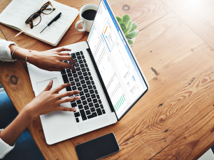 A leasing agent looking at communication analytics on an apartment CRM solution on a laptop