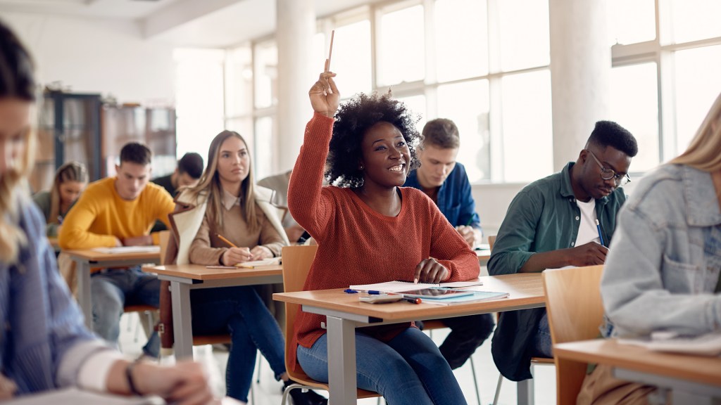 Students raising hands at desks