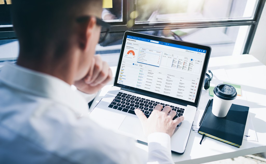 A property manager using Yardi CRM IQ on a laptop computer